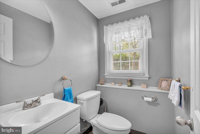 bathroom featuring toilet, visible vents, and vanity