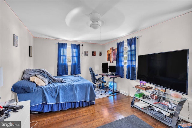 bedroom with ceiling fan, baseboards, visible vents, and wood finished floors