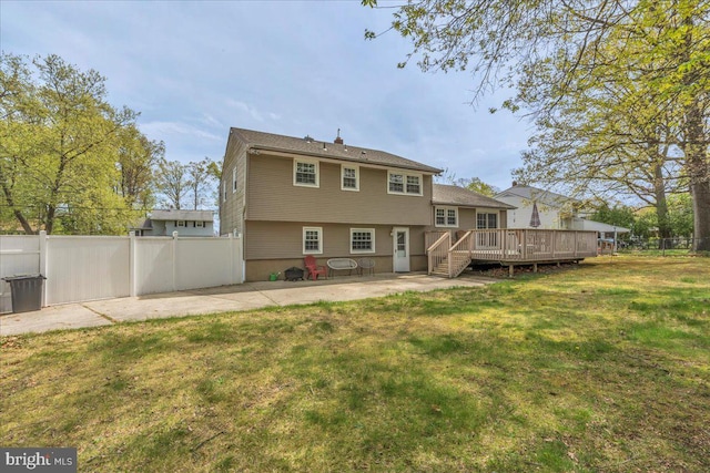rear view of property with a yard, a patio, fence, and a deck