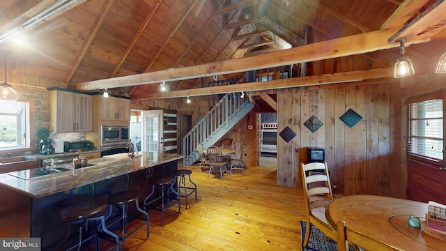 21165 State Road 55, Wardensville, WV 26851 - kitchen featuring appliances with stainless steel finishes, wood ceiling, wooden walls, light wood-type flooring, and a kitchen bar