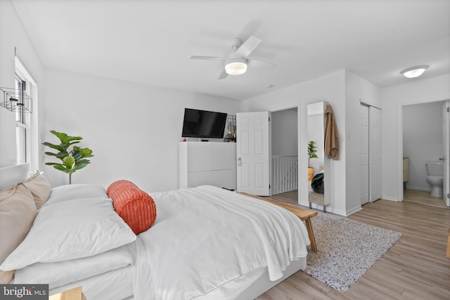 bedroom featuring a ceiling fan, baseboards, light wood-style flooring, and ensuite bathroom