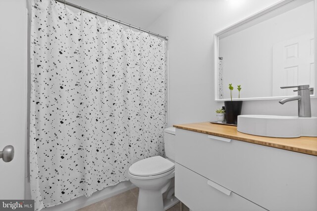bathroom featuring vanity, tile patterned flooring, a shower with curtain, and toilet