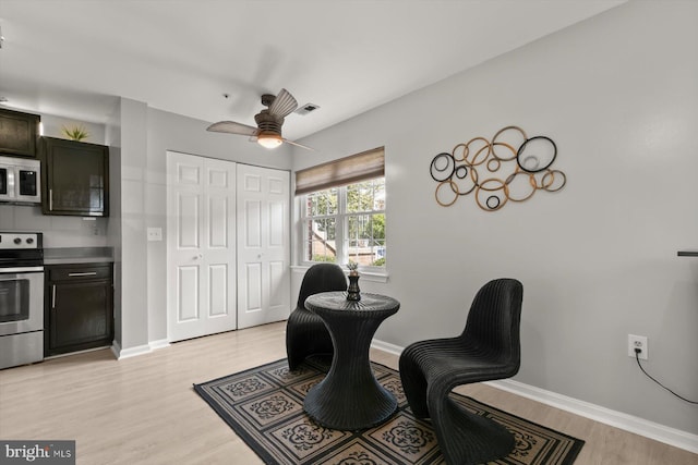 sitting room featuring baseboards, a ceiling fan, light wood-style flooring, and visible vents