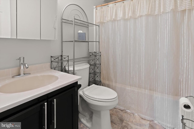 full bath with vanity, shower / bath combo, and toilet