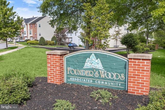 community sign featuring a yard and a residential view