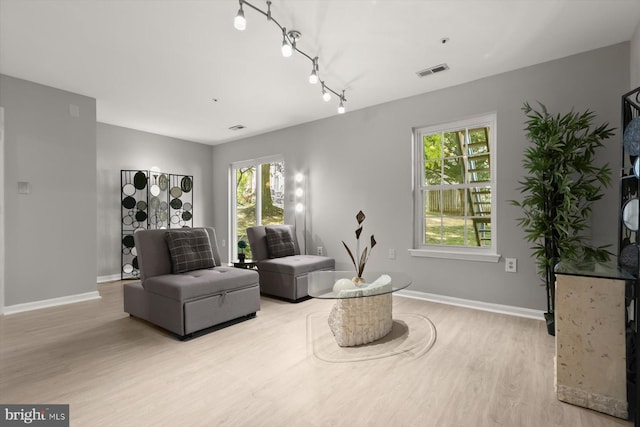 living room with visible vents, baseboards, a wealth of natural light, and light wood-type flooring