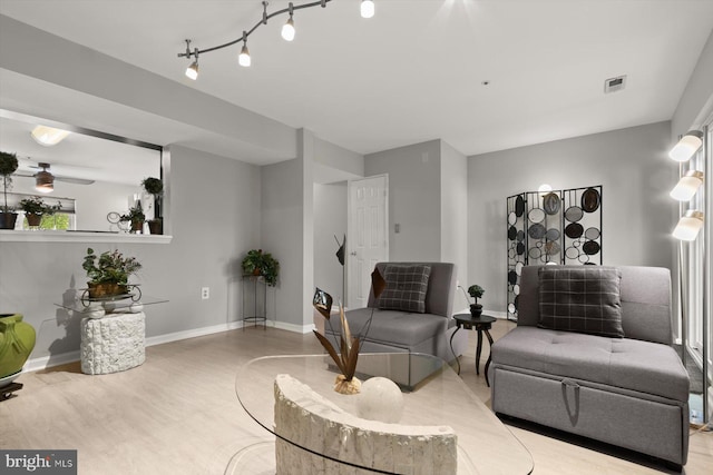 living room featuring baseboards, visible vents, and wood finished floors