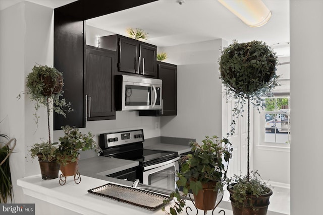 kitchen with light countertops, dark cabinetry, and stainless steel appliances
