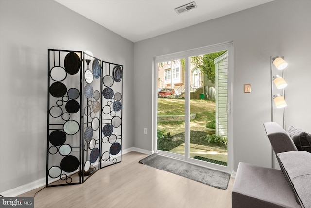 entryway featuring baseboards, wood finished floors, and visible vents