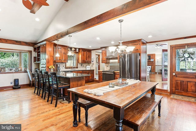 dining space with recessed lighting, light wood finished floors, a wealth of natural light, and ceiling fan with notable chandelier
