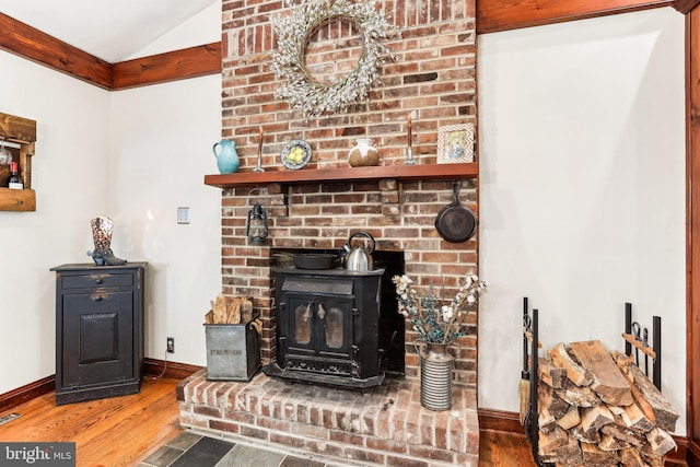 room details with baseboards, a wood stove, and wood finished floors