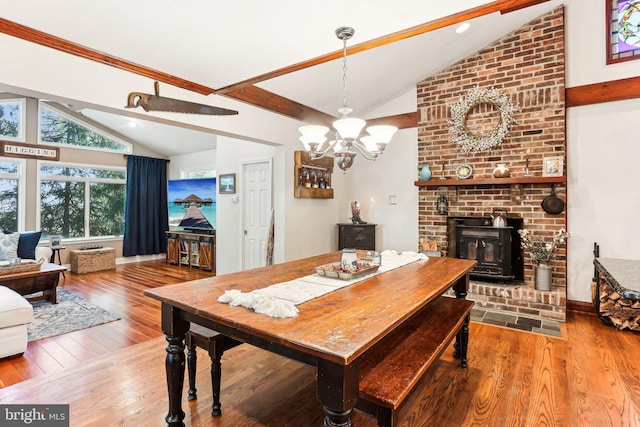 dining room with baseboards, lofted ceiling, a chandelier, and hardwood / wood-style floors