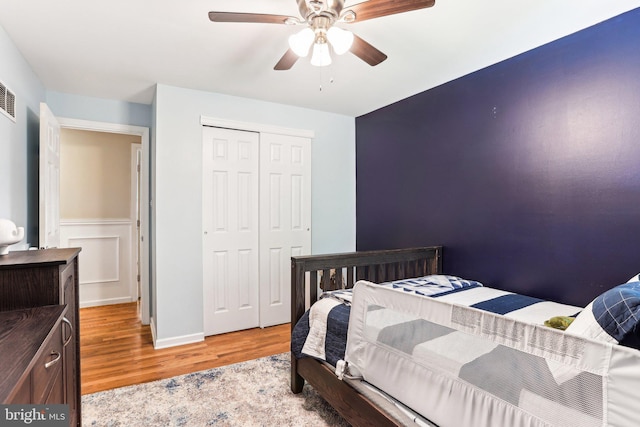 bedroom featuring a closet, light wood finished floors, and ceiling fan