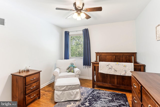 bedroom featuring a ceiling fan, baseboards, and light wood finished floors