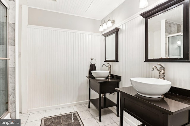 full bath with a sink, a shower with door, two vanities, and ornamental molding