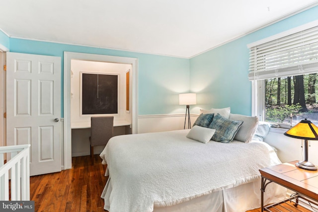 bedroom featuring ornamental molding and wood finished floors