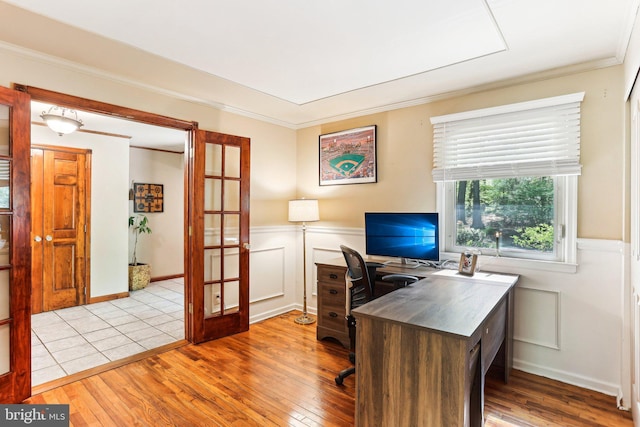 office with crown molding, wainscoting, hardwood / wood-style flooring, and french doors