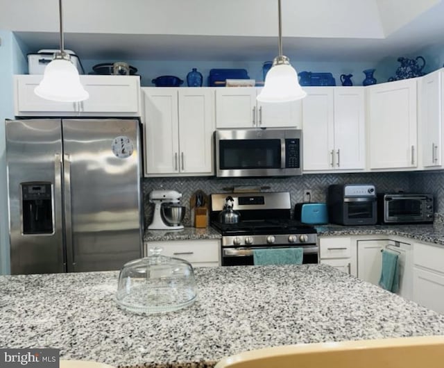 kitchen featuring a toaster, white cabinetry, tasteful backsplash, decorative light fixtures, and stainless steel appliances