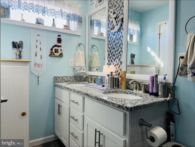bathroom featuring a sink and double vanity