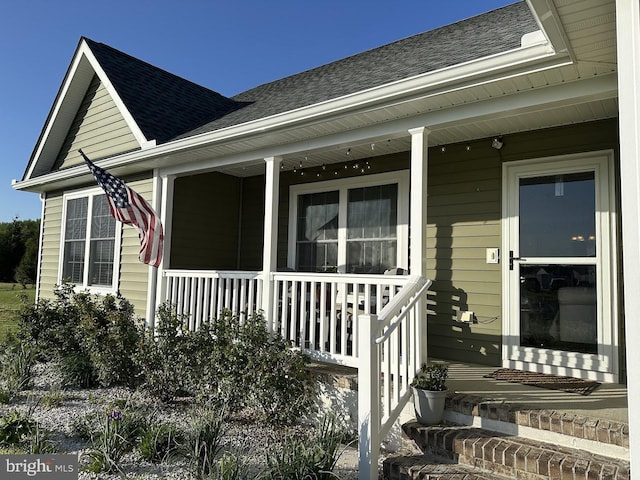 exterior space with a porch and a shingled roof