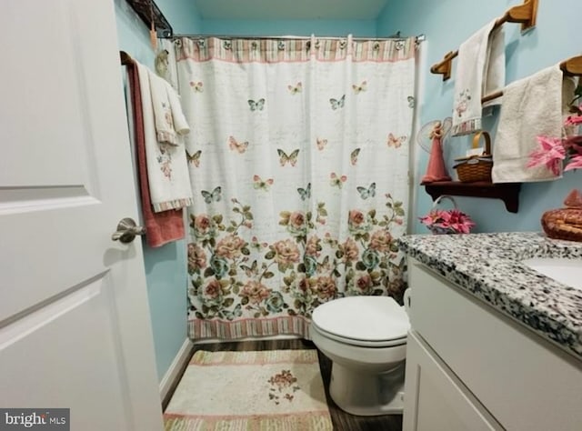 bathroom featuring vanity, a shower with shower curtain, and toilet