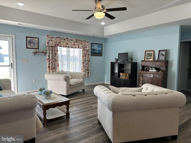 living area with a ceiling fan, baseboards, dark wood-style floors, and plenty of natural light