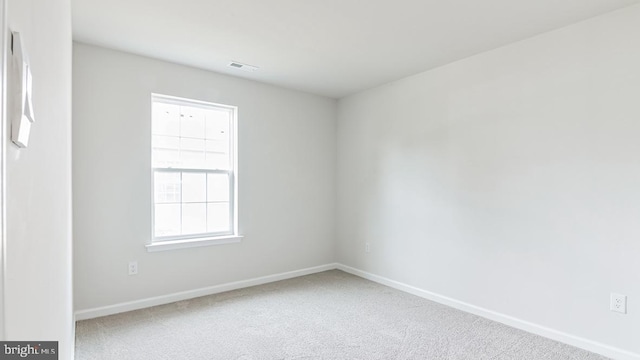 carpeted empty room with visible vents and baseboards