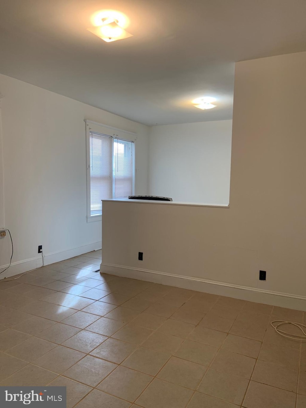 empty room featuring light tile patterned floors and baseboards