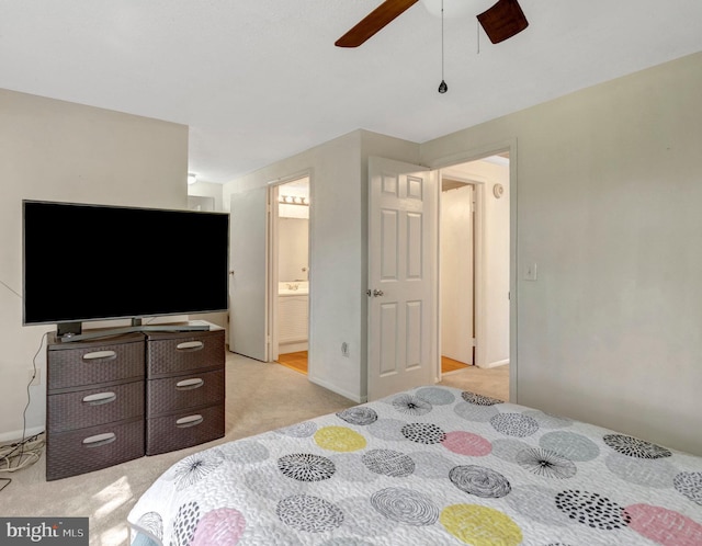 bedroom with connected bathroom, a ceiling fan, baseboards, and light carpet