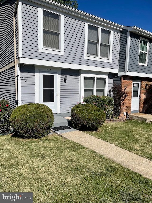 view of front of home with brick siding and a front yard