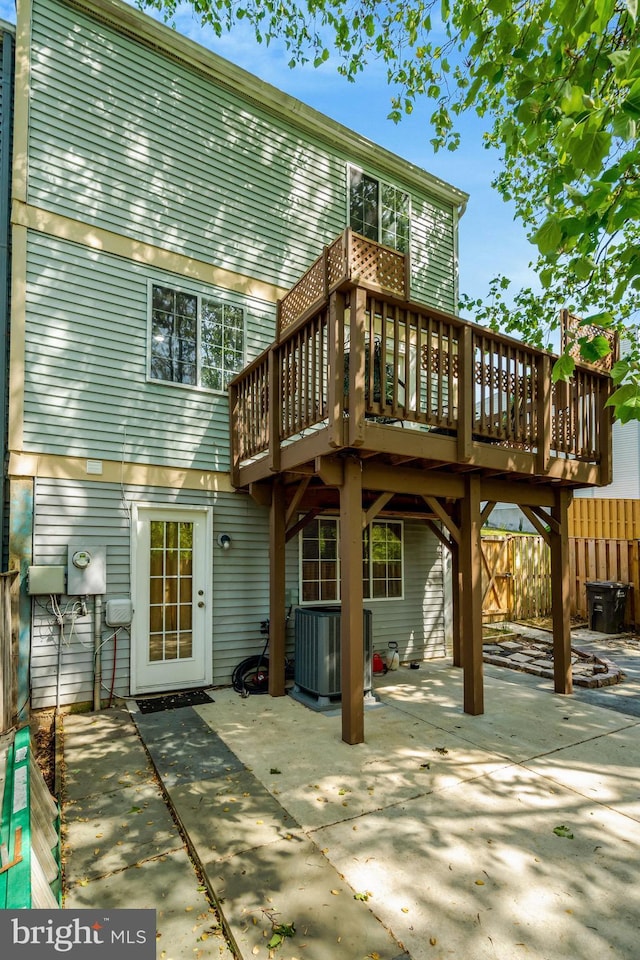 rear view of house with central AC unit, a patio area, fence, and a deck
