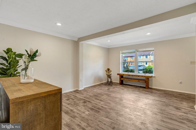 interior space with baseboards, ornamental molding, recessed lighting, and wood finished floors