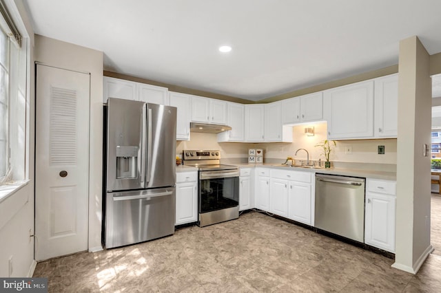 kitchen featuring appliances with stainless steel finishes, a sink, light countertops, white cabinets, and under cabinet range hood