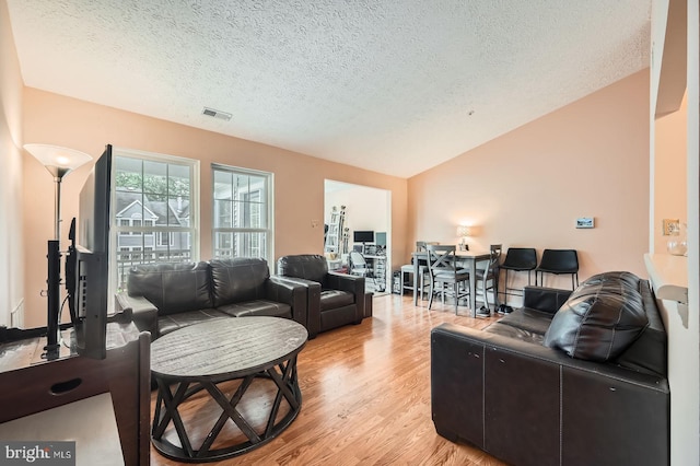 1317 Greenbriar Cir Unit 7-1317, Pikesville, MD 21208 - living area featuring a textured ceiling, light wood-style floors, and lofted ceiling
