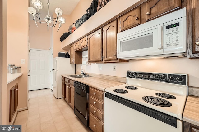 1317 Greenbriar Cir Unit 7-1317, Pikesville, MD 21208 - kitchen with white appliances, a sink, light countertops, a chandelier, and light flooring