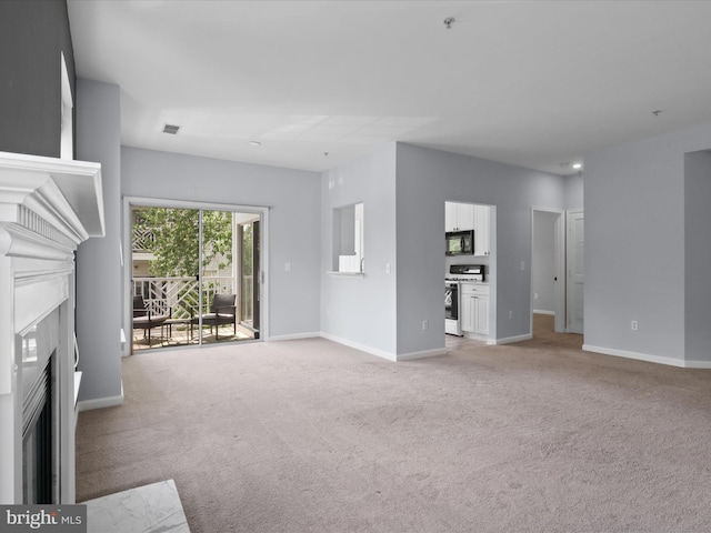 unfurnished living room featuring a fireplace with flush hearth, baseboards, and light carpet