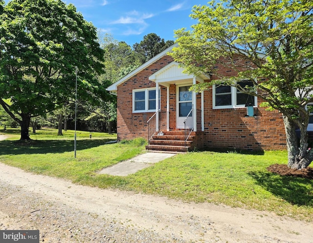 bungalow-style home with a front lawn and brick siding