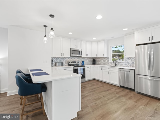327 Oakwood St, Bethany Beach, DE 19930 - kitchen with stainless steel appliances, a peninsula, white cabinets, and recessed lighting
