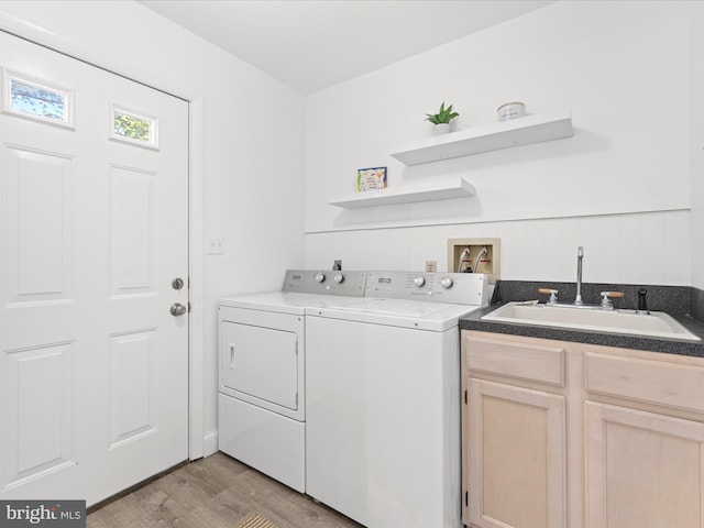 327 Oakwood St, Bethany Beach, DE 19930 - washroom featuring washing machine and dryer, light wood-style floors, and cabinet space