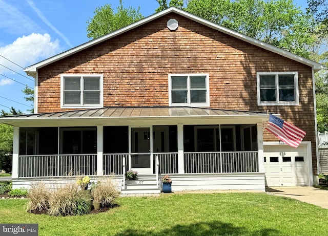 327 Oakwood St, Bethany Beach, DE 19930 - view of front of house featuring a sunroom, a standing seam roof, a front lawn, and driveway