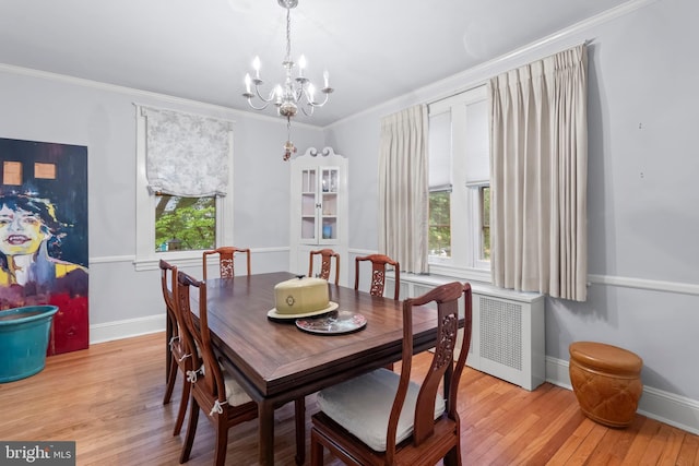 dining space with a chandelier, light wood-style flooring, radiator, ornamental molding, and baseboards