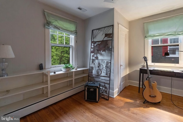 misc room featuring baseboard heating, wood finished floors, and baseboards