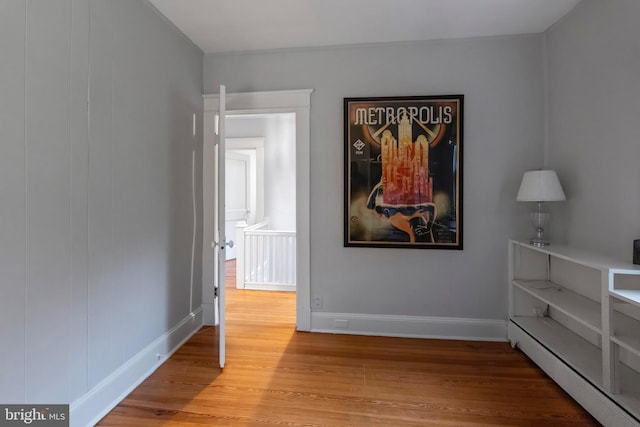 unfurnished bedroom with wood finished floors and baseboards