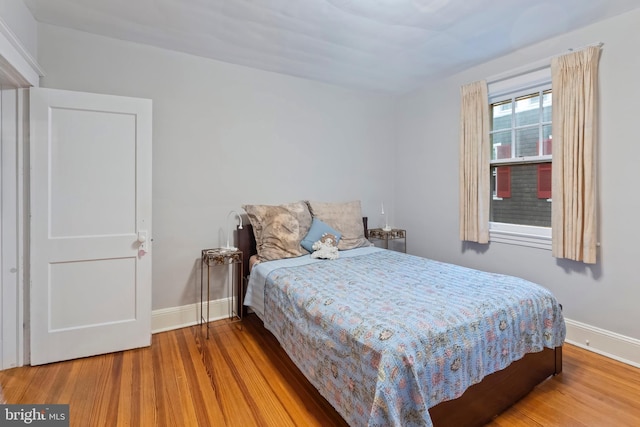 bedroom featuring baseboards and wood finished floors