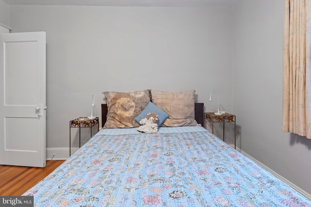 bedroom featuring wood finished floors and baseboards