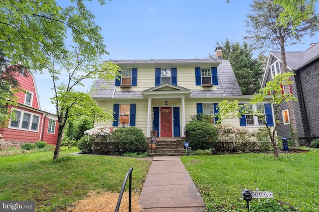 view of front of house featuring a chimney and a front lawn
