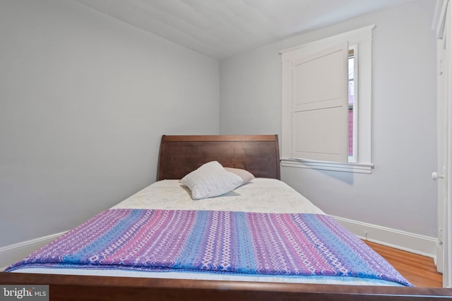 bedroom with wood finished floors and baseboards