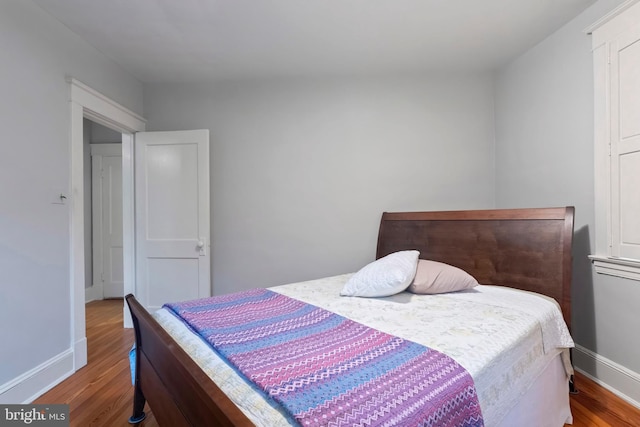 bedroom featuring wood finished floors and baseboards