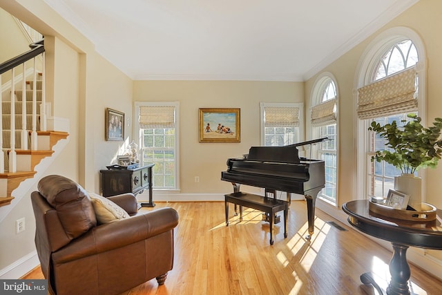 sitting room with crown molding, baseboards, stairway, and light wood-type flooring