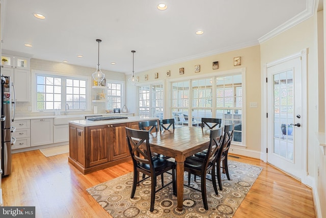 dining space with crown molding, recessed lighting, and light wood-style flooring